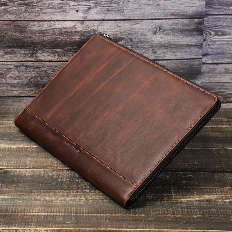 Brown leather portfolio on a wooden surface