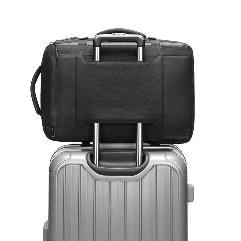 Black travel bag stacked on top of a silver suitcase on a white background