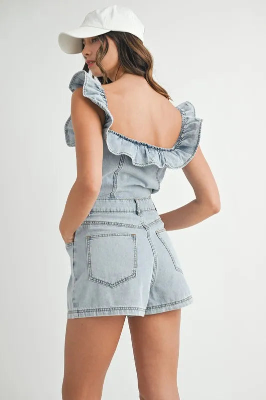 Woman wearing a light blue denim dress with ruffled straps on a white background