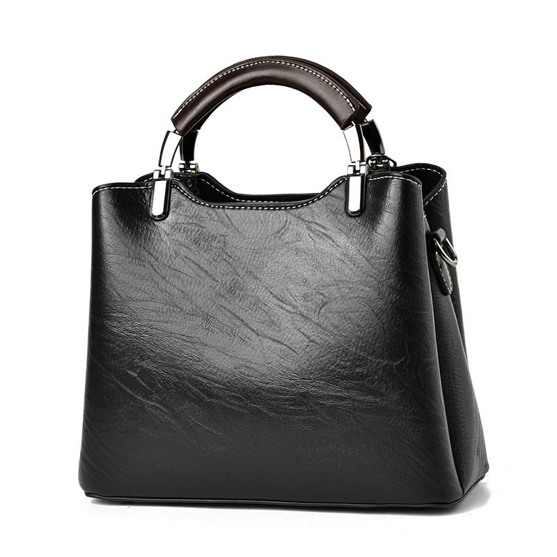 Black handbag with a glossy finish on a white background
