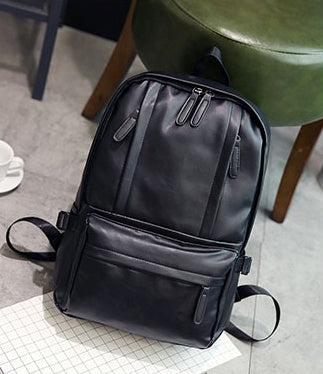 Black backpack on a checkered floor with a chair in the background