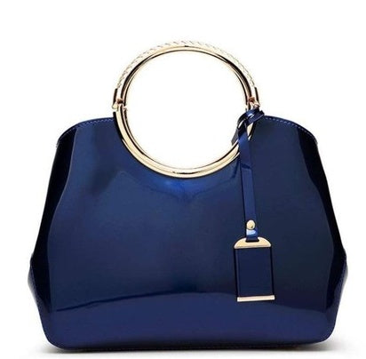 Blue handbag with gold handle and clasp on a white background