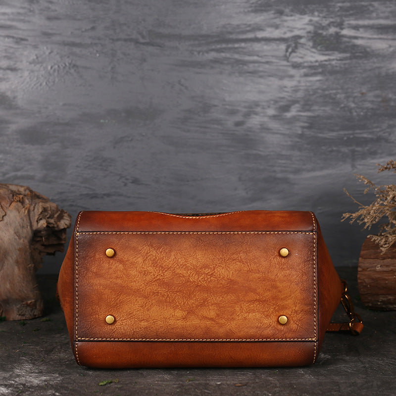 Brown leather bag with gold studs on a dark textured background