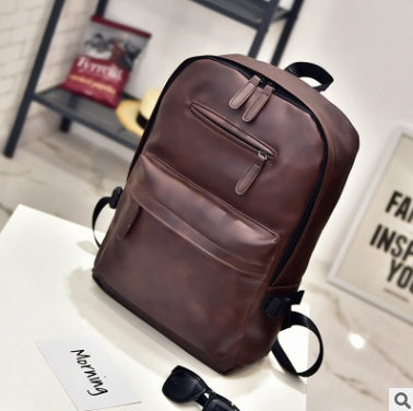 Brown backpack on a white surface with a blurred background