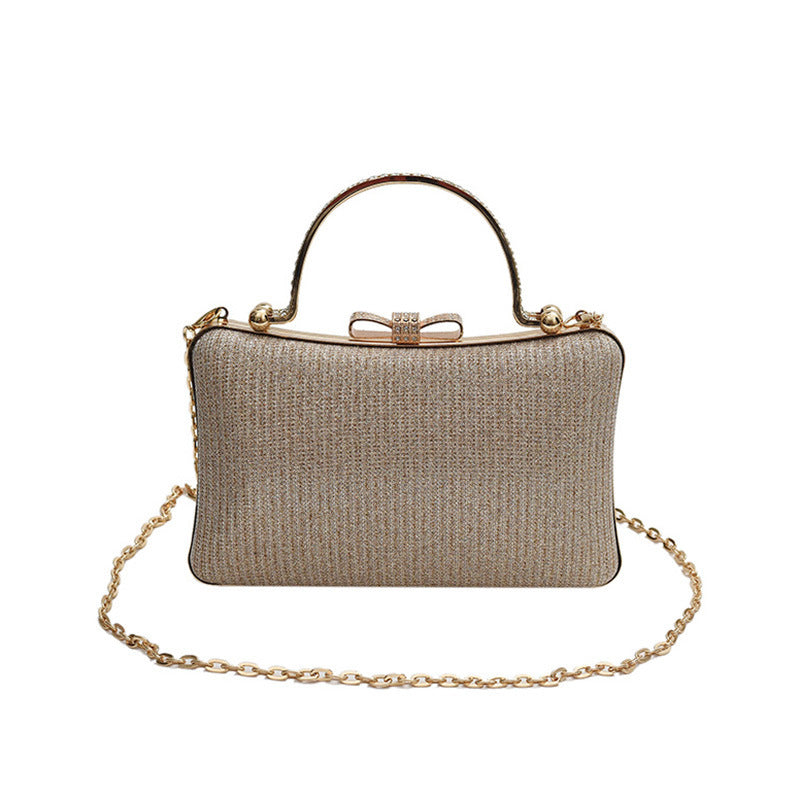 Gold clutch bag with a chain strap on a white background