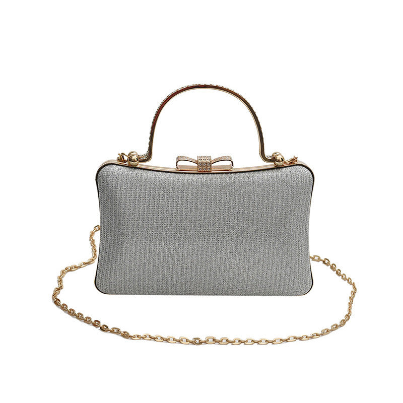 Gray clutch bag with gold chain and handle on a white background