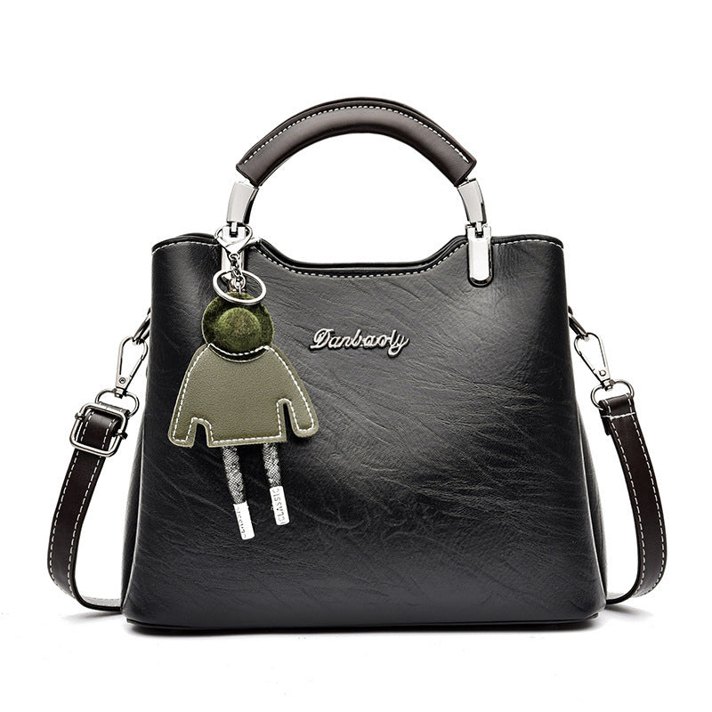 Black handbag with a unique charm on a white background