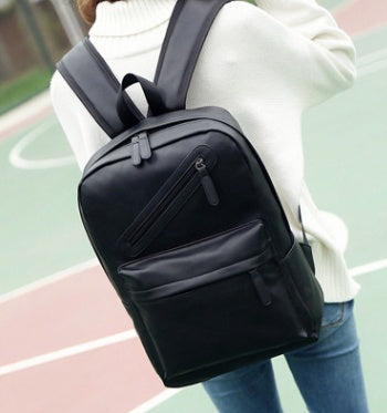 Black backpack worn by a person on an outdoor court