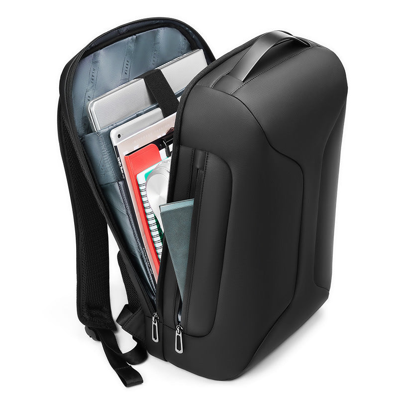 Black backpack with compartments containing books and a laptop on a white background