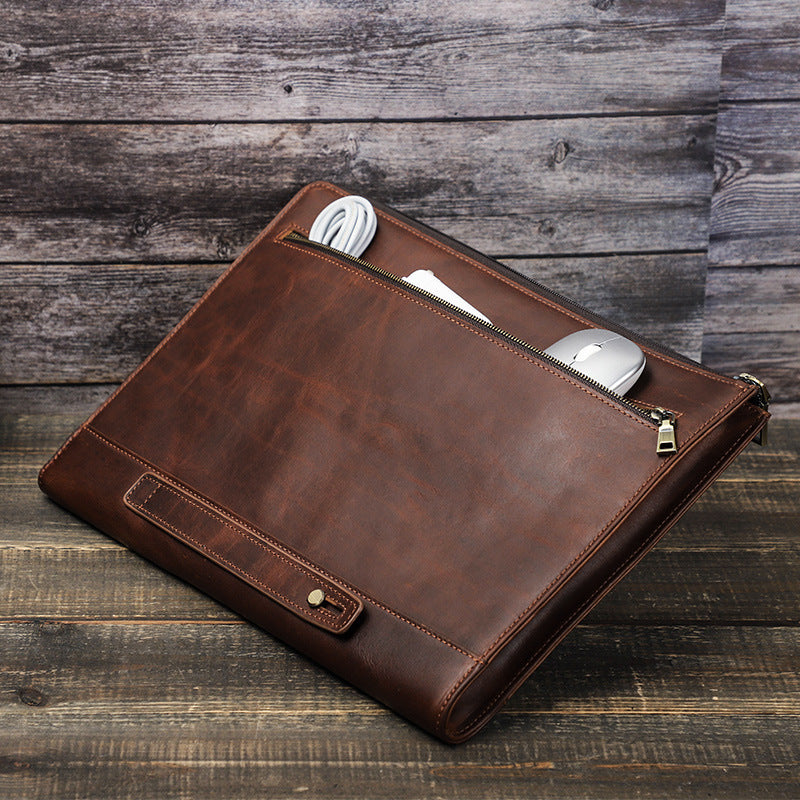 Brown leather briefcase with compartments on a wooden surface
